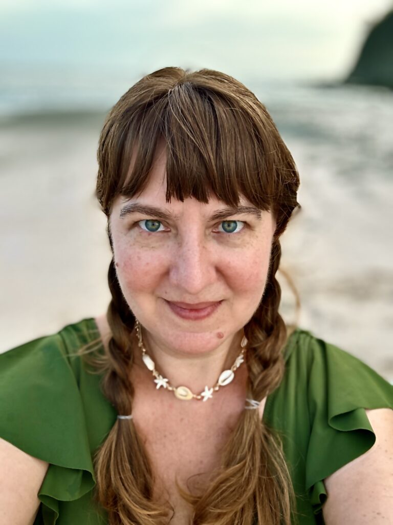 Portrait of Chloe on beach with hair in braids.