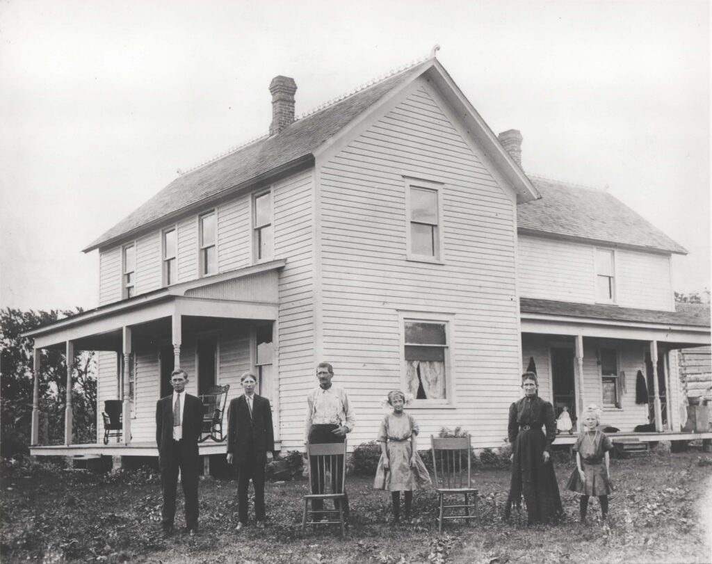 1900s family portrait in front of farm house